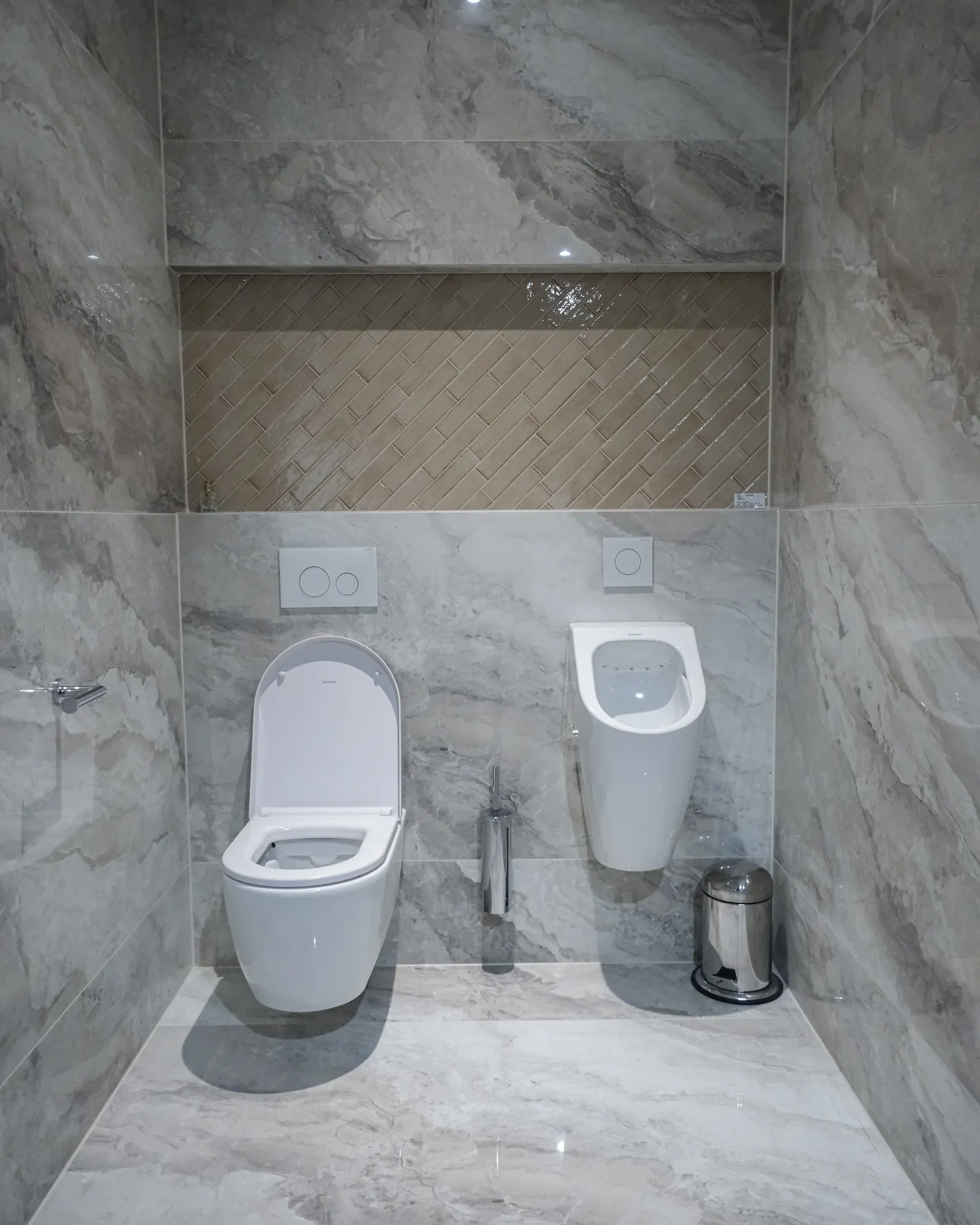 Toiletruimte in grijze marmerlook met urinoir